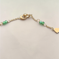 Златна гривна със сърчица и зелени цирконий