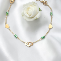 Златна гривна със сърчица и зелени цирконий