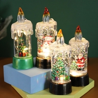 Decoratiune de Craciun tip Lumanare, Flippy, Lumanare de Cristal cu Fulgi de Zapada, Model Mos Craciun cu Sclipici, Iluminare LED, 13 x 5 x 5 cm, Baza Vintage Bronze, Transparent