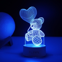 Lampa LED decorativa, Flippy, 3D, Ursulet cu balon inima, cu telecomanda, doua moduri de alimentare USB si baterii, 20 cm inaltime, din material acril si lumina multicolora, alb