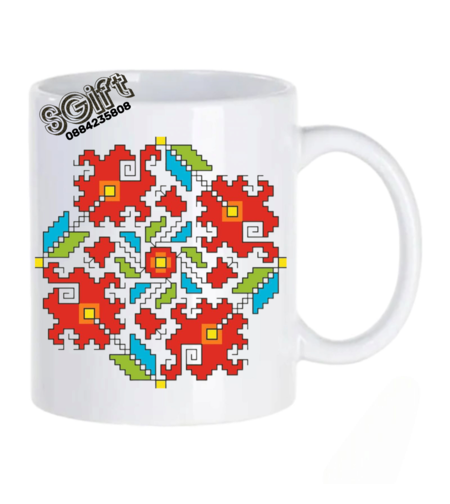 Бяла керамична чаша с голяма цветна българска шевица в червено, зелено и синьо от giftparadise.bg.