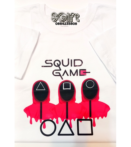 Бяла памучна детска тениска с голям принт на трима охранители от Squid Game с ефект на разтичаща се розова боя и графични символи под тях.