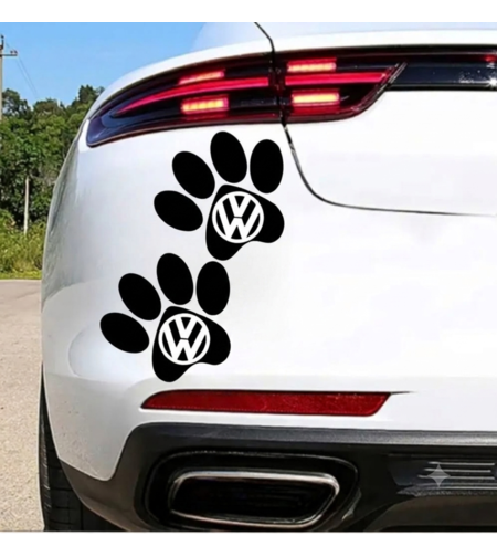 Черен стикер изобразяващи кучешки лапички с вградено лого на Volkswagen, залепени върху задната част на бял автомобил.