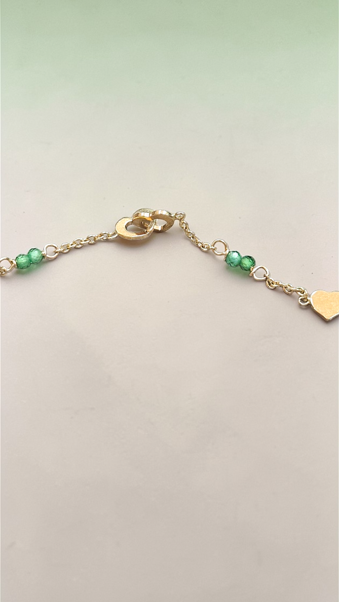 Златна гривна със сърчица и зелени цирконий