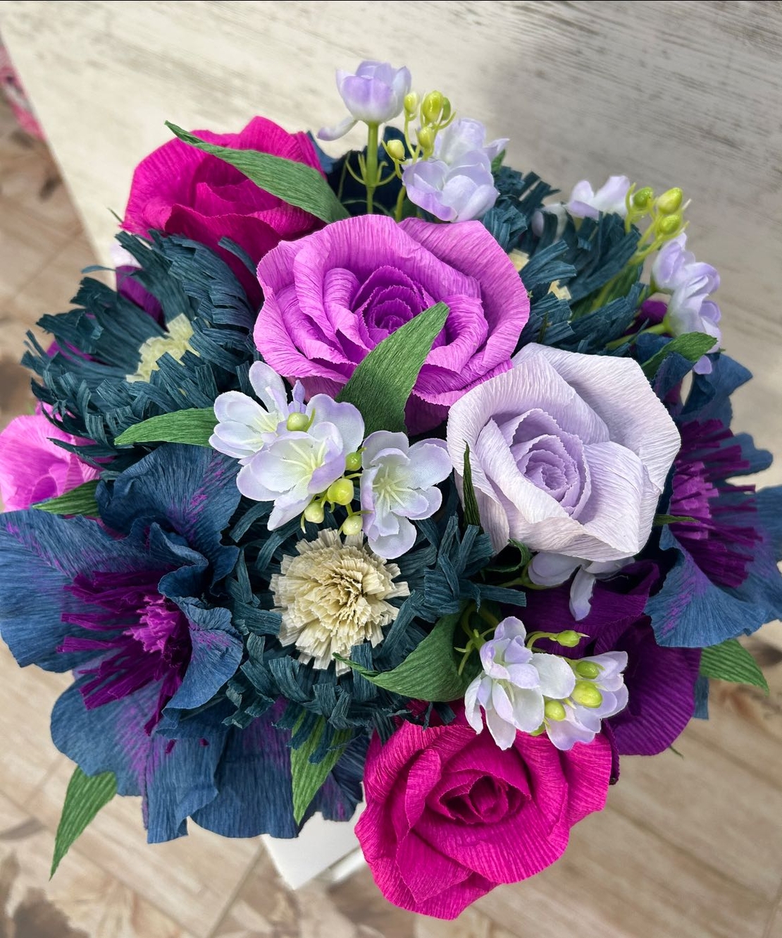 Лилави,розови и сини цветя в бяла кутия с лилава панделка