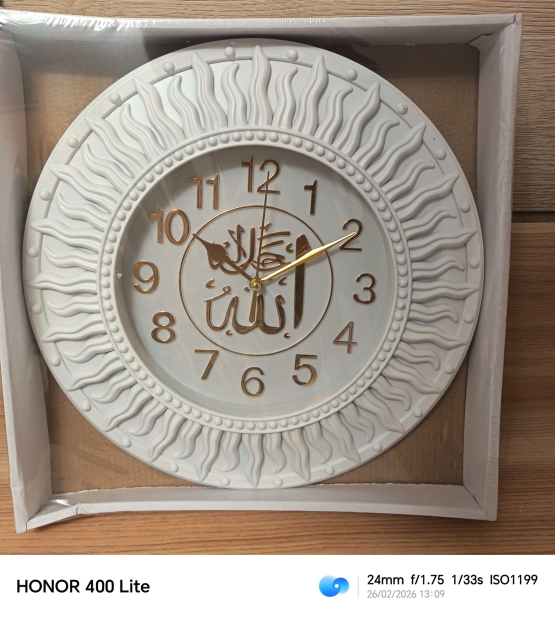 Стенен часовник с ислямски мотиви в бял и златист цвят.