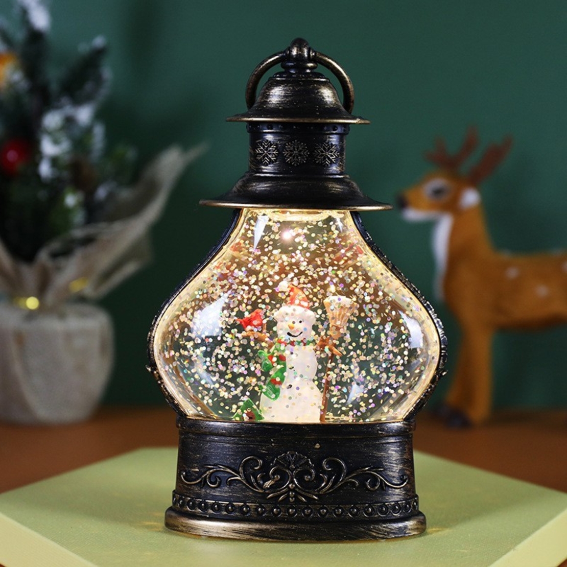 Decoratiune de Craciun tip Felinar, Flippy, Glob de Cristal cu Fulgi de Zapada, Model Om de Zapada, Ornamentat cu Luminite Interioare, 14.5 x 9 x 3 cm, Rama Neagra, Transparent